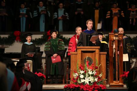 Chris Mathews, professor of music and department chair, leads in the singing of the Alma Mater during fall commencement services.  - Photo by Kristi McMurry Woody