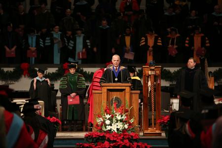 Bill Nance, acting dean of the McAfee School of Business Administration, gives the benediction for the second fall commencement service.  - Photo by Kristi McMurry Woody