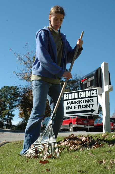Art major Heather Couch rakes leaves at Birth Choice during Day of Remembrance. - Photo by Amanda Herron