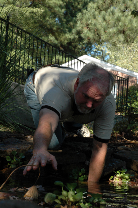 Brent Lambert, Birth Choice's director, worked along with the Union volunteers as he pulled weeds in a pond during Day of Remembrance. - Photo by Amanda Herron
