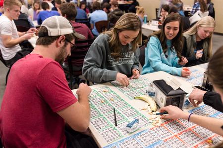 From left to right, Jesse Dalms, Mary Jo Stinson, Hannah Richardson and Allie Malone munch on snacks while searching for matches during Bingo Night in the Brewer Dining Hall. - Photo by David Parks