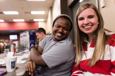 Student Activities Council members Kael Moore, senior interdisciplinary studies major and Jessica Vinyard, senior mathematics major, pose for a photo behind the prizes table during Bingo Night.  - Photo by David Parks