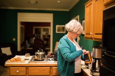 Nancy Thomas, associate director of the center for faculty development, prepares coffee and tea for guests in her home during Be Our Guest, a Student Activities Council event. - Photo by Kristi McMurry Woody