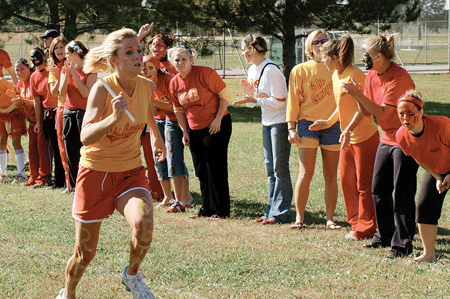 Junior Blaire Collins, nursing major, races
for the finish line as her XO sisters line the track to cheer her on. - Photo by Kristen Hiller