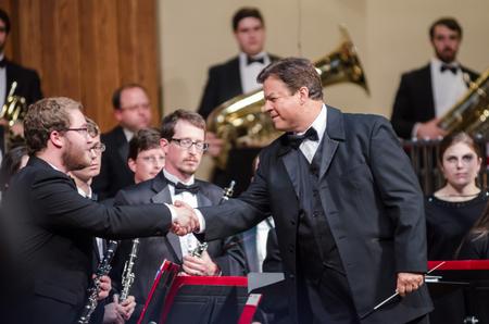 Before his clarinet solo, Jordan Methenia, junior music major, is encouraged by conductor Michael Mann. - Photo by David Parks