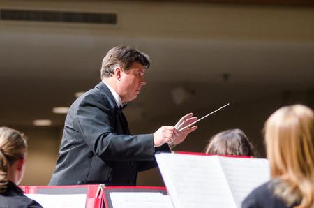 Michael Mann, professor of music, carefully conducts a complex piece during the Symphonic Band concert. - Photo by David Parks