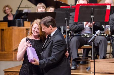 Senior music major Alexis Piscatello receives an honorary gift from Michael Mann, her music professor for four years, near the end of the Symphonic Band concert. - Photo by David Parks