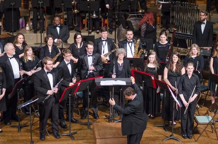 With the final piece complete, conductor Michael Mann directs audience's applause to the Symphonic Band for their excellent concert. - Photo by David Parks