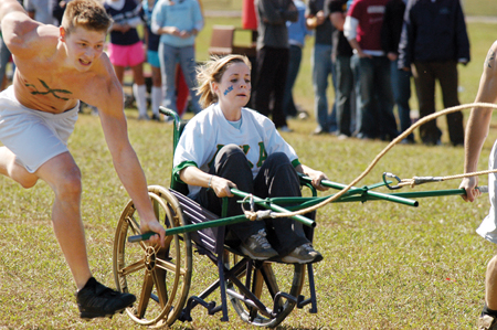 Junior Amanda Raley, psychology major, holds on tight as sophomore Blake Pennington, management major loses control of the LXA chariot. Although nobody was seriously hurt, questions remain concerning future chariot races.
 - Photo by Kristen Hiller