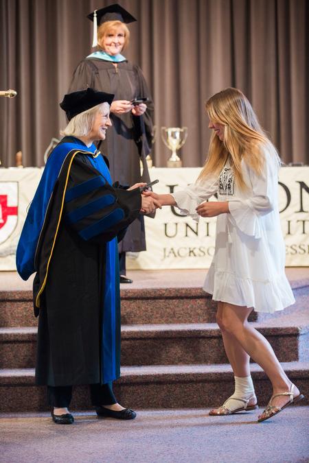 Jeannette Russ, professor of engineering and department chair, presents Chelsea Johnson with the academic excellence award in mechanical engineering during Awards Day Chapel. - Photo by Kristi McMurry Woody