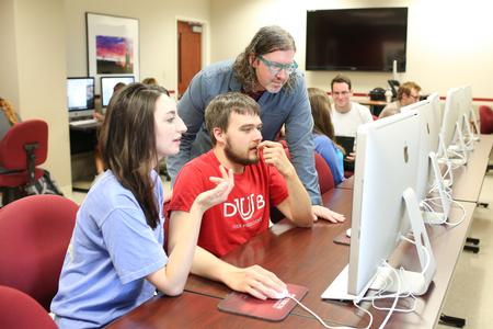 Ted Kluck, assistant professor of communication arts, chats with some students about their writing before class. - Photo by Kristi McMurry Woody