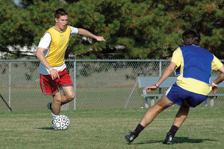 Sophomore Duncan Nicol, physical education
and health major, drills with his teammate during a practice session.
 - Photo by Amanda Herron