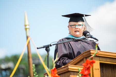 Melessia Mathis, assistant professor of education, reads Joshua 1:1-9 at the beginning of spring commencement services.  - Photo by Kristi McMurry Woody