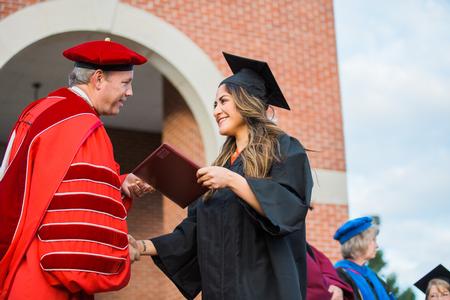 Patricia Regalado, art graduate, happily receives her diploma during spring commencement services.  - Photo by Kristi McMurry Woody