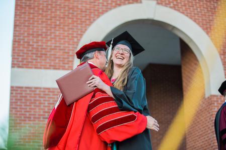 Ruthie Johnson, Christian studies graduate, hugs Dub Oliver, president of the university, as she receives her diploma.  - Photo by Kristi McMurry Woody