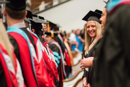Graduates laugh together and wave at friends and family at the beginning of Summer Commencement.  - Photo by Kristi McMurry Woody