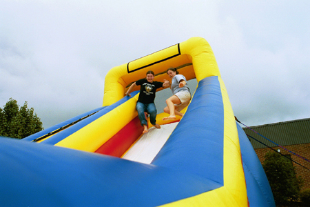 Students Amanda Smith and India Hickman race down the bouncy slide at Fall Fest 2002. - Photo by Kristen Hiller