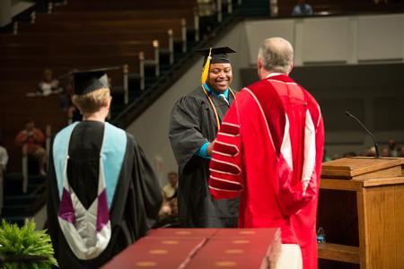 Andre Marshall, BSOL graduate, receives his diploma from Dub Oliver, president of the university, during Summer Commencement.  - Photo by Kristi McMurry Woody
