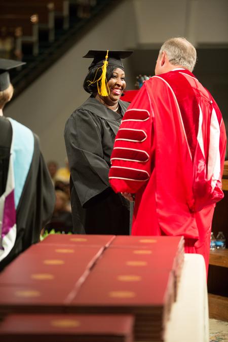 Tameka Scott, BSOL graduate, happily receives her diploma during Summer Commencement. - Photo by Kristi McMurry Woody
