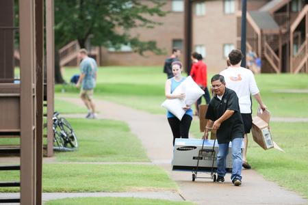 Don Van, professor of engineering, helps move new students into their rooms in Heritage. - Photo by Kristi McMurry Woody