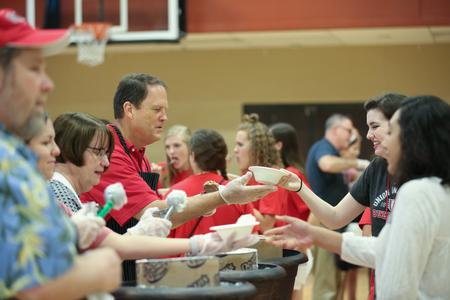 Gary Carter, senior vice president for business services, helps serve ice cream to new students during Welcome Week. - Photo by Kristi McMurry Woody