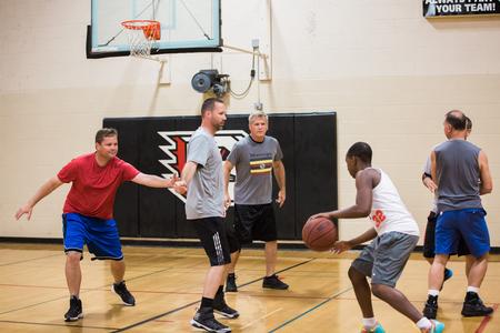 Faculty, staff and students play a game of pickup basketball in the activities center gym. - Photo by Kristi McMurry Woody