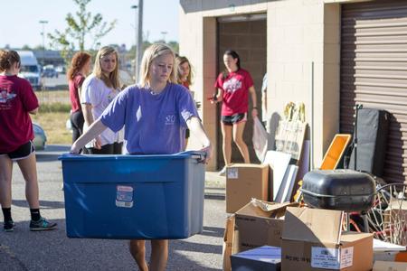 Jennifer Briley, freshman business administration major, moves a box out of the storage unit for the Boys & Girls Club in Humboldt during the annual Campus and Community Day.  - Photo by Morgan Morfe
