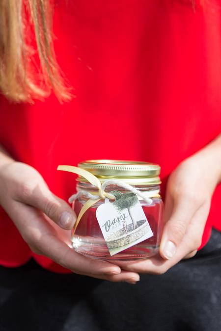 Summer Basham, freshman biology major, holds an Oasis mason jar in honor of Leighton Williams. The water in the jar came from the well of the Oasis memorial.  - Photo by Morgan Morfe