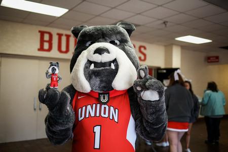 Buster the Bulldog poses with his bobblehead likeness before the basketball games on Saturday. - Photo by Kristi McMurry Woody