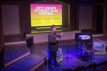 Chris Blair, professor of communication Arts professor and coordinator of DMS, introduces student directors at the Student Film Festival.  - Photo by Morgan Morfe
