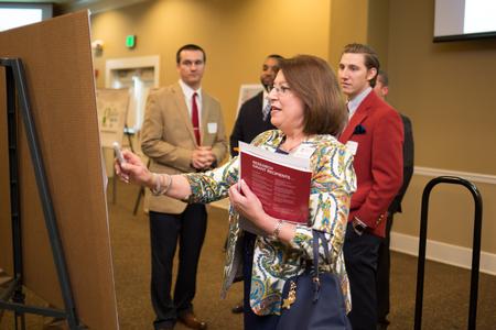 Connie Cupples, professor of nursing, asks some questions about a student project during the Scholarship Symposium poster presentations. - Photo by Kristi McMurry Woody