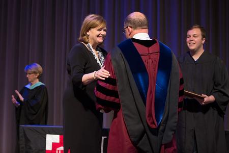 Carla Sanderson congratulates Scott Huelin, professor of English, on being named Faculty Member of the Year during Awards Day chapel. - Photo by Kristi McMurry Woody