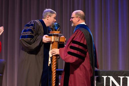 Web Drake, 2015-2016 Faculty Member of the Year, passes off the mace to the newly announced 2016-2017 recipient Scott Huelin. - Photo by Kristi McMurry Woody