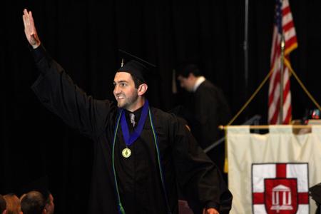 Felipe Rocha, business graduate, waves to the friends after receiving his diploma at the class of 2017 graduation ceremony.  - Photo by Riley Boggs