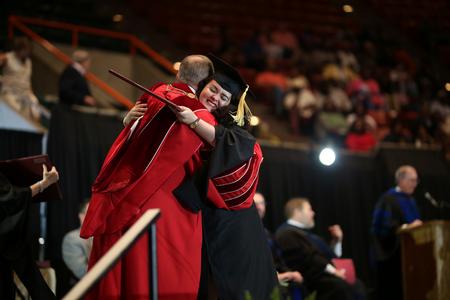 Esperanza Gonzalez, master of social work graduate and associate director for student success, hugs Dub Oliver, president of the university, after receiving her diploma during spring commencement.  - Photo by Kristi McMurry Woody