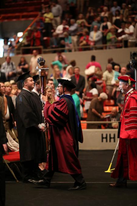Scott Huelin, professor of English and current faculty member of the year, leads the recessional at the conclusion of spring commencement. - Photo by Kristi McMurry Woody
