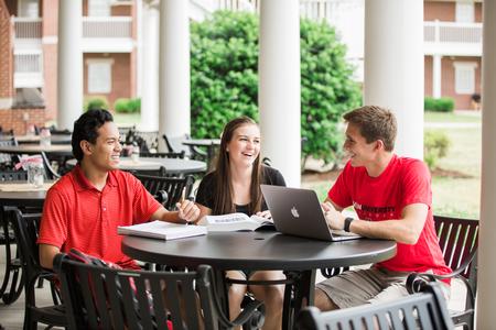 Binh Morris, sophomore business administration major, Amelia Kangas, freshman TESL major, and Stephen Neu, junior business administration major, chat on the Bowld patio one afternoon. - Photo by Kristi McMurry Woody