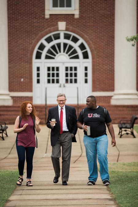 Mattanah DeWitt, freshman journalism major, Greg Jordan, professor of business law and ethics, and Justice Walker, junior mathematics major, walk toward White Hall on a spring day.  - Photo by Kristi McMurry Woody