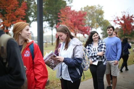 Students look through the newest edition of the Cardinal & Cream magazine while in line for a donut from The Donut Truck.  - Photo by Kristi McMurry Woody