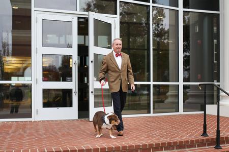 Dub Oliver, president of the university, heads out of the library with Buster the Bulldog. - Photo by Kristi McMurry Woody