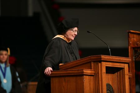 Mary Anne Poe, dean of the school of social work, prays at the beginning of fall graduation for graduate and BSOL students.  - Photo by Kristi McMurry Woody