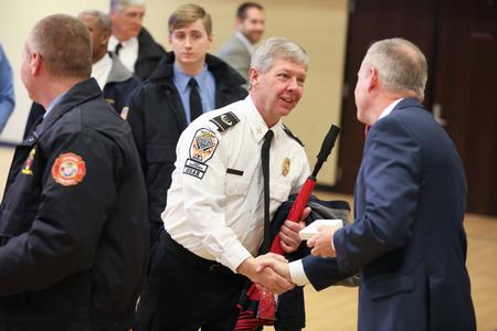 Dub Oliver, president of the university, hands out commemorative coins to first responders during the "God in the Whirlwind" event commemorating the 10 year anniversary of the 2008 tornado. - Photo by Kristi McMurry Woody