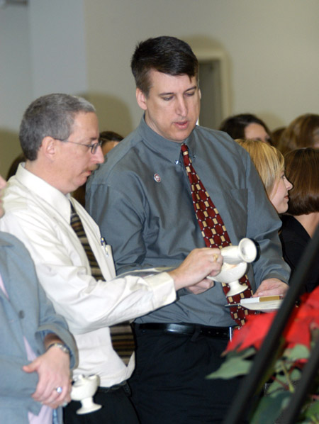 Nursing as a Second Degree graduates Jack Prince & Kenneth Preston participate in the lamplighting ceremony prior to fall graduation 2004. - Photo by Jonathan Blair