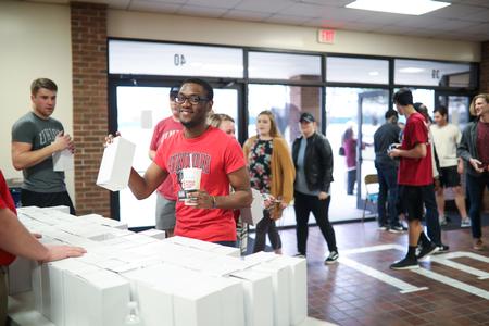 Cedric Davis, history major, picks up his Dub Oliver bobblehead before the conference tournament game in the Fred Delay Gym. - Photo by Kristi McMurry Woody