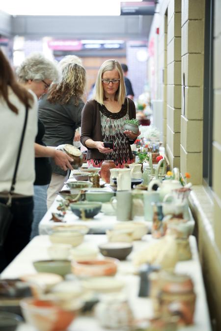 Janie Steinbach, coordinator of continuing education and faculty support in the College of Pharmacy, picks out a student-made piece of pottery at the Mother's Day Pottery Sale. - Photo by Kristi McMurry Woody