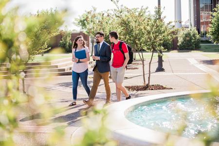 Jacob Shatzer (center), associate dean of the school of theology and missions, chats with Haley Hathcock, biology major, and Eli Creasy, art major, outside Jennings Hall. - Photo by Kristi McMurry Woody