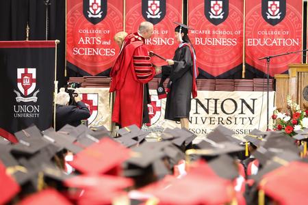 Shaolu McLaren, master of arts in education graduate, receives her diploma from Dub Oliver, president of the university, during spring commencement. - Photo by Kristi McMurry Woody