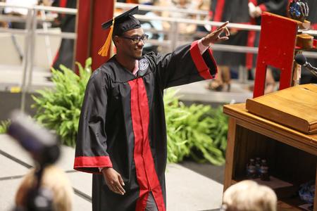 Cedric Davis, history graduate, celebrates as he walks across the stage to receive his diploma during spring commencement services.  - Photo by Kristi McMurry Woody