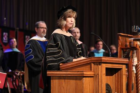 Karen Miller, professor of accounting and director for academic research, reads the opening scripture for summer graduation. - Photo by Kristi McMurry Woody
