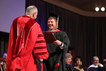 Bailey Bell, master of business administration graduate, receives his diploma during summer graduation. - Photo by Kristi McMurry Woody